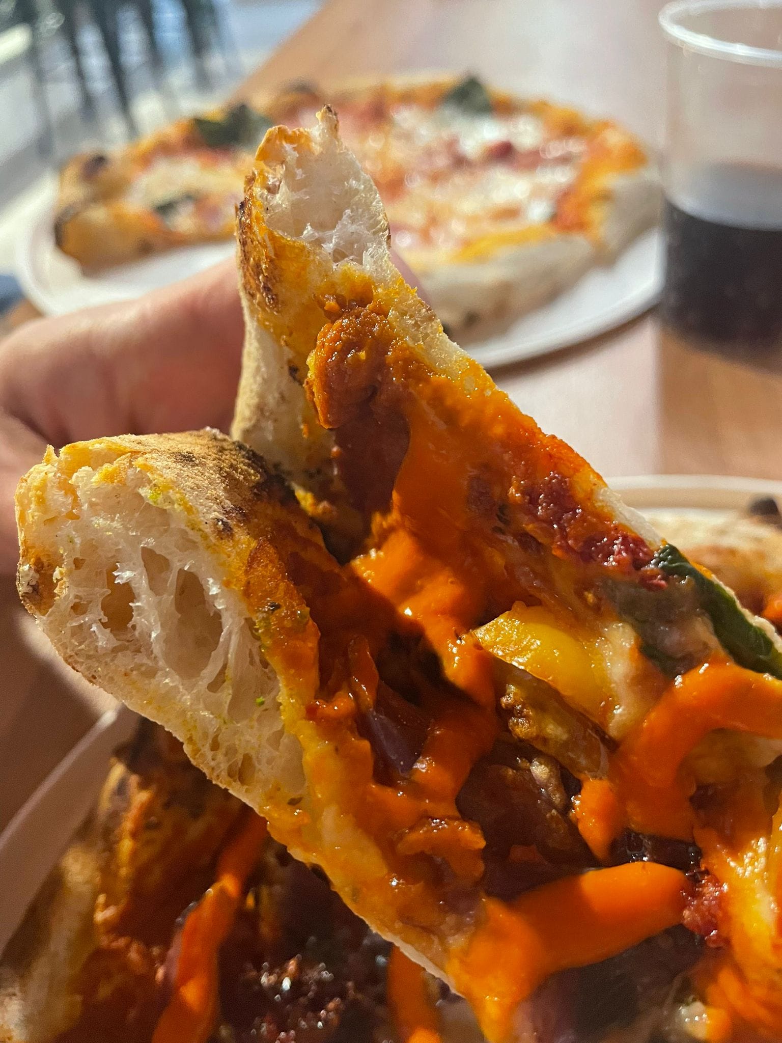 Pizza napoletana in cui si vedono gli alveoli dell'impasto che donano la sua famosa morbidezza, questà è una pizza con crema alla nduja e cipolla di tropea